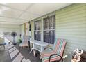 Inviting porch with striped chairs, a table, and an array of plants, creating a relaxing outdoor space at 4719 Dove Cross Dr, Lakeland, FL 33810