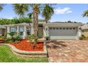 Charming home with a brick paver driveway, a two-car garage, and well-maintained landscaping at 10367 Addison Shore Way, Oxford, FL 34484