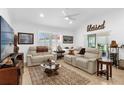 Bright living room with neutral decor, comfortable seating, and a decorative ceiling fan at 10367 Addison Shore Way, Oxford, FL 34484
