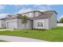 Charming two-story home with a manicured lawn, showcasing the home's curb appeal at 13275 Tula Loop, Astatula, FL 34705