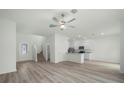 Open-concept living area with wood-look floors and neutral tones with a staircase at 13275 Tula Loop, Astatula, FL 34705