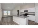 Bright kitchen features stainless steel appliances, gray countertops, white cabinets, and an island at 1022 Foreshore Ln, Haines City, FL 33844
