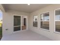 Covered patio with sliding glass doors, windows, and view of the landscaped yard at 1022 Foreshore Ln, Haines City, FL 33844