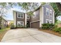 Two-story home with brown siding, white trim, attached two-car garage and concrete driveway at 1300 Holly Glen Run, Apopka, FL 32703
