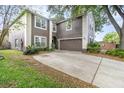 Two-story home with brown siding, white trim, attached two-car garage and concrete driveway at 1300 Holly Glen Run, Apopka, FL 32703