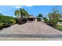 Charming home featuring a golf cart, and a brick driveway lined with mature landscaping at 2991 Wood Duck Dr, Polk City, FL 33868