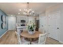Open-concept design flows into the dining area with modern chandelier, and eat-in kitchen at 3766 King Hill Dr, Haines City, FL 33844