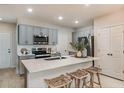 Stylish kitchen with gray cabinets, stainless steel appliances, quartz countertops, and wicker barstools at 3766 King Hill Dr, Haines City, FL 33844