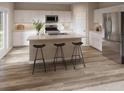 Bright eat-in kitchen showcasing an island with bar stool seating, stainless steel appliances, and light wood flooring at 3787 King Hill Dr, Haines City, FL 33844
