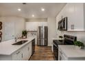 Bright kitchen with white cabinets, stainless steel appliances, an island, and hardwood floors at 3795 King Hill Dr, Haines City, FL 33844