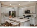 A modern kitchen with white cabinets, stainless steel appliances, and a center island with bar stool seating at 3795 King Hill Dr, Haines City, FL 33844