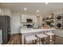 Modern kitchen featuring white cabinets, stainless steel appliances, a quartz island, and hardwood floors at 3795 King Hill Dr, Haines City, FL 33844