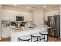 Well-lit kitchen with white cabinets, stainless steel appliances, and a center island with seating at 3799 King Hill Dr, Haines City, FL 33844