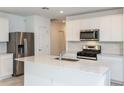 Modern kitchen features stainless steel appliances, ample counter space, and sleek white cabinetry for a stylish cooking experience at 9084 Wildlight Trl, Wildwood, FL 34785