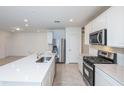 Bright kitchen boasts a large center island, stainless steel appliances, and an adjacent living area at 9084 Wildlight Trl, Wildwood, FL 34785