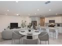 Bright open-concept living area seamlessly blends the living room and modern kitchen, perfect for relaxation and entertaining at 9084 Wildlight Trl, Wildwood, FL 34785