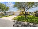 Charming two-story home with a lush lawn and a spacious driveway leading to a two-car garage at 440 Langham Dr, Davenport, FL 33897