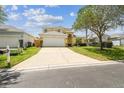 Charming two-story home with a lush lawn and a spacious driveway leading to a two-car garage at 440 Langham Dr, Davenport, FL 33897
