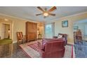 Cozy living room with stylish decor, comfortable seating, and a decorative ceiling fan at 6589 Banyan Dr, Indian Lake Estates, FL 33855
