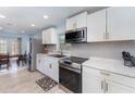 Modern kitchen featuring stainless steel appliances and white cabinets with gold handles at 820 Lamp Post Ln, Lakeland, FL 33809