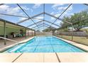 Sparkling screened-in pool with a spacious deck area and lush landscaping at 820 Lamp Post Ln, Lakeland, FL 33809