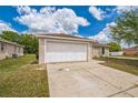 Well-maintained single-story home with a two-car garage and long concrete driveway at 1628 Saddlehorn Dr, Lakeland, FL 33810