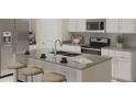 Modern kitchen featuring stainless steel appliances, a spacious island with seating, and white cabinetry at 4730 Golden Knight Blvd, Kissimmee, FL 34746