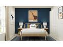 Stylish bedroom with dinosaur-themed art, a wooden bed frame, and blue accent wall at 947 Hour Glass Rd, Lakeland, FL 33801