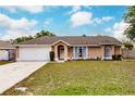 Charming single-story home featuring a two-car garage, manicured lawn, and lovely front entrance at 206 Chris Ct, Davenport, FL 33896