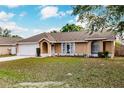 Charming single-story home featuring a two-car garage, manicured lawn, and lovely front entrance at 206 Chris Ct, Davenport, FL 33896