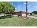 Landscaped front lawn with palm tree, brick driveway, and charming one-story home at 622 Jamaica Cir, Lakeland, FL 33803