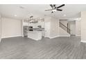 Open-concept living area with gray floors, a modern kitchen, and a staircase at 7717 Somersworth Dr, Kissimmee, FL 34747