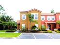 Charming townhome with a terracotta tile roof, lush landscaping, and an assigned parking spot for convenient access at 151 Pompano Beach Dr, Kissimmee, FL 34746