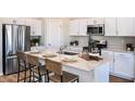 Modern kitchen featuring white cabinets, stainless steel appliances, and an island with a breakfast bar at 1034 Foreshore Ln, Haines City, FL 33844