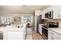 Modern kitchen features white cabinets, stainless steel appliances, large island, and an eat in dining area at 4047 Gardenia Ave, Lake Hamilton, FL 33851