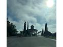 View of the community entrance with fountain and palm trees on a partly cloudy day at 3205 Sonesta Ct # B, Clermont, FL 34711