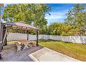 Backyard with a gazebo, picnic table, white privacy fence, storage shed, and mature trees at 2448 Brownwood Dr, Mulberry, FL 33860