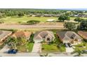 Aerial view of home with lush landscaping, golf course views, and a three car driveway at 2522 Pine Valley Dr, Lakeland, FL 33810