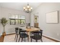 Well-lit dining room with a modern chandelier, table set for six, and large window at 100 Essex Dr, Longwood, FL 32779