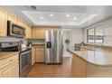 Spacious kitchen features stainless steel appliances, wood cabinets, and granite countertops at 100 Essex Dr, Longwood, FL 32779
