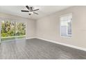 Bright living room with sliding glass doors, ceiling fan, and sleek wood flooring offers seamless indoor-outdoor living at 7756 Somersworth Dr, Kissimmee, FL 34747