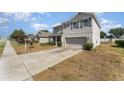 Inviting two-story home featuring a spacious driveway, neat landscaping, and a welcoming front porch at 5597 Forest Ridge Dr, Winter Haven, FL 33881