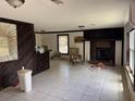 A living room features tile floors, paneled accent wall, fireplace and accent chair at 10931 Pathfinder Trl, Lakeland, FL 33809