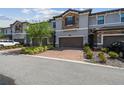 Well-maintained townhome with stone accents, brick driveway, two-car garage, and well-kept landscaping at 1209 Payne Stewart Dr, Davenport, FL 33896