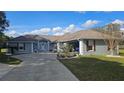 Charming home featuring a gray exterior, well-manicured lawn, and covered front porch at 6975 Sw 99Th St, Ocala, FL 34476