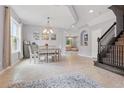 Bright dining room featuring tiled flooring, modern chandelier, and staircase at 12243 Sawgrass Reserve Blvd, Orlando, FL 32824