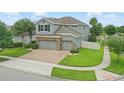 Aerial view of a home with a brick driveway, three-car garage, manicured lawns, and fenced yard at 12243 Sawgrass Reserve Blvd, Orlando, FL 32824