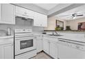 This kitchen features white cabinets, white appliances and tile flooring at 337 Scottsdale Sq # 337, Winter Park, FL 32792