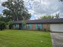 Charming single-story brick home with blue shutters, well-maintained lawn, and mature shade trees at 4506 Se 7Th Pl, Ocala, FL 34471