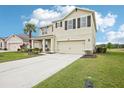 Two-story home featuring a two-car garage, well-kept lawn, and ample driveway space at 3387 Tawny Grove Pl, Lakeland, FL 33811